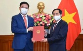 新任外交部副部長范光效(左)從外交部長裴青山手中接過人事委任《決定》。(圖源:國際報)