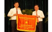市人委會主席阮成鋒(右)向取得本市2020年競賽運動出色成績的單位頒發競賽錦旗。