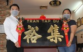 趣兒記者(右)把木雕老招牌捐贈給陳列室。
