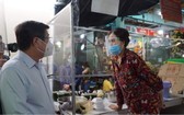 7月18日上午,市人委會主席阮成鋒(左)親往視察第十一郡平泰街市復業情況。(圖源:VNN)