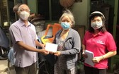 圖為本市一名貧困者(中)領取輔助金。(圖源:孟和)