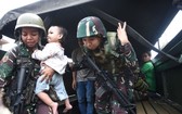 菲律賓馬拉維6月25日，一名軍人懷抱一名被解救的嬰兒。