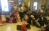 乘客們因為航班多次延後而滯留於機場苦等。