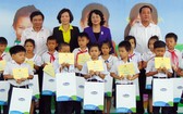 國家副主席鄧氏玉盛（後排右二）向維貞鄉清貧優秀生贈送奶品和助學金。（圖源：玉詩）