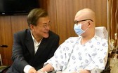 8月9日，文在寅（左）訪問位於首爾瑞草區的首爾聖母醫院，並與病人親切交談。（圖片來源：韓聯社）