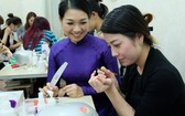 華人美甲師龐美玲（左）正在教學員美甲技藝。