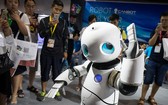 參觀者在7月8日舉行的北京國際電子消費展上觀看機器人跳舞。（圖源：VCG）