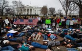 學生躺臥在白宮前的行人路抗議。（圖源：AP）