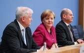 3月12日，在德國首都柏林，德國總理、基民盟主席默克爾（中），社民黨代主席肖爾茨（右）和基社盟主席澤霍費爾出席新聞發佈會。（圖源：新華網）