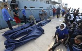 在利比亞的黎波里一個海軍基地，海岸警衛隊人員準備搬運非法移民遺體。（圖源：新華網）