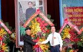 吳策實同志(右)代表越南祖國陣線中央委員會向和好佛教教會中央理事長贈送鮮花祝賀。（圖源：國忠）