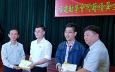市民族處副主任梁鴻德(左一)與溫陵會館 理事長張子諒(右一)頒發獎學金給碩士畢業生。