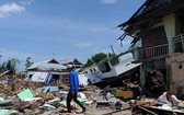 10月5日，在印度尼西亞中蘇拉威西省棟加拉縣，災民在房屋廢墟中尋找可用物品。（圖源：新華網）