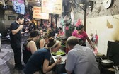 導遊向外國遊客介紹河內市同春街市小食。
