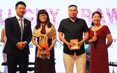 中國聯通越南總經理崔俊（左一）與中國商會本市分會秘書長吳美林（右一）向幸運兒頒發聯通產品。
