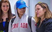 拉哈芙(中)身著寫有“加拿大”字樣的灰色運動帽衫、頭戴印有聯合國難民署標誌的棒球帽步出機場。（圖源：AFP）