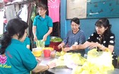 楊氏月主任(右一)為窮人準備膳食。