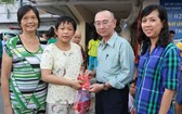 本報編委兼編輯部主任范興(右二)向患上腦腫瘤的華人病童陳雅珍贈送禮物代金。