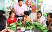 同奈省天平孤兒 院小朋友們正品嚐志願者所烹煮的飯菜。