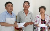 本報慈善組人員將讀者樂捐善款轉交予貧病華人。