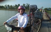 黃友喬老師用摩托車載自行車騎過廣治省趙峰縣趙度浮橋，以給該地學生們贈送車子。