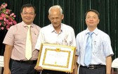 第五郡領導向華人黨員葉南如頒發50年黨齡紀念章。