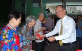穗城會館理事長盧耀南向高齡鄉親贈送利是。