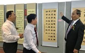馮利發（左二）與林漢城（左一）陪同柬埔寨教育部國務秘書麥砂綸參觀越南區書法。