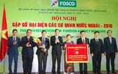 市人委會常務副主席黎清廉(左四)代表市人委會向FOSCO公司贈送傳統錦旗。