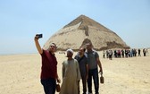 7月13日，人們在埃及首都開羅以南的彎曲金字塔前拍照。（圖源：新華社）