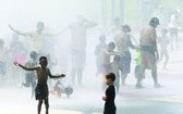 市民在噴水設施除去外衣消暑。（圖源：互聯網）