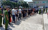 我國警方在中國廣西東興市北崙河大橋向中國警方移交28名網絡犯罪嫌疑人，以及電腦、手機等一批作案工具。（圖源：警方提供）