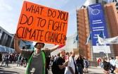 在比利時布魯塞爾民眾手持標語參加氣候變化遊行。（圖源：新華社）