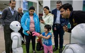 人們與人形機器人互動。（圖源：新華社）