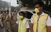 11月4日早晨，志願者和警察戴著防毒口罩站在新德里的十字路口，手舉牌子“服從單雙號限行，消除污染”。（圖源：AP）