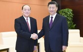 中國國家主席習近平（右）會見賀一誠。（圖源：新華社）