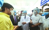 大水鑊醫院院長阮知識醫生向病人李子超(黃衣)遞交出院證。