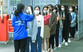 河內市所屬新聞與宣傳學院的大學生進校時接受額溫檢測。（圖源：VOV）