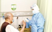 昨(26)日晚，武漢市肺科醫院，最後一名轉陰者丁爹爹和醫護人員互相鼓勵。（圖源：互聯網）