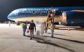 從阿拉伯聯合酋長國撤回的越南公民抵達芹苴機場下機時接受噴灑消毒。（圖源：VNA）