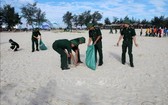 廣治省由靈縣青年官軍、士兵及共青團員在沙灘上撿拾垃圾，攜手保護環境。（圖源：越通社）