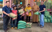 該廟慈善組組長鄒國榮（左一）和寶光寺住持（右二）向貧困少數民族同胞派發濟貧禮物。