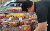 一名新加坡消費者在當地超市選購越南荔枝。（圖源：越通社）