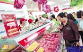 消費者在超市選購豬肉。（圖源：越勇）