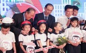 張和平副總理（後左一）出席“圓夢”活動並親切為小學生扣上安全帽。（圖源：教育部）