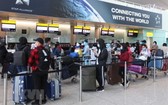 從英國撤回的我國公民在 Heathrow 機場辦理行李托運手續。（圖源：越通社）