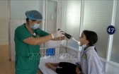 醫生在為一名白喉患者檢查咽喉症狀。（圖源：越通社）