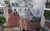 消防隊員爬上隔壁鐵皮屋頂展開滅火行動。（圖源：消防警察提供）