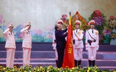 政府總理阮春福代表黨及國家領導為越南人民公安傳統旗幟上佩掛一等軍功勳章。（圖源：杜忠）