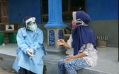 一名印尼紅十字會的志願者為一位受疫情影響的當地市民提供心理救助。